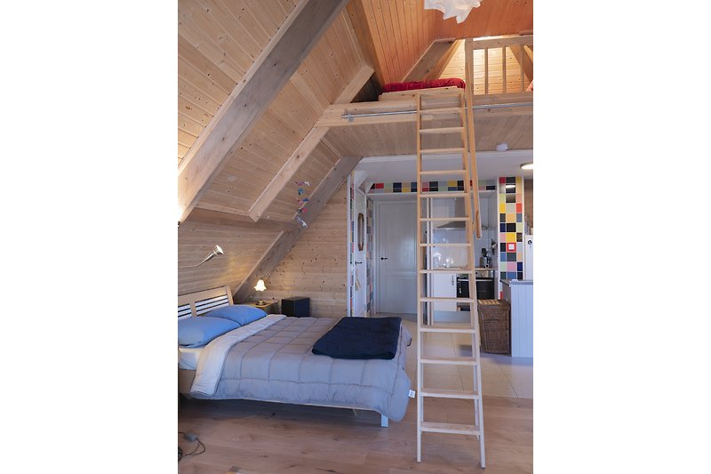 Schlafzimmer mit bequemem Bett und Holzmöbeln.