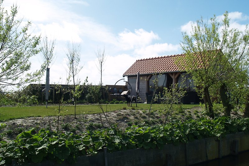 Ländliches Bauernhaus mit Garten und Feldern.