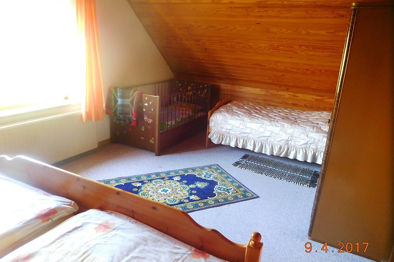 Elternzimmer verfügt über ein Ehebett, ein Gitterbett und ein Einzelbett.