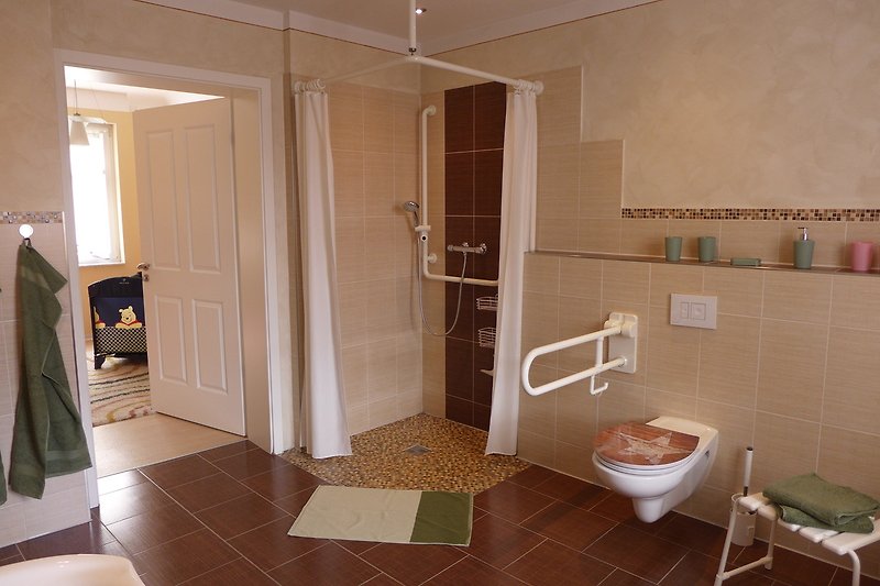 Elegantes Badezimmer mit Dusche, Marmor und modernen Armaturen.