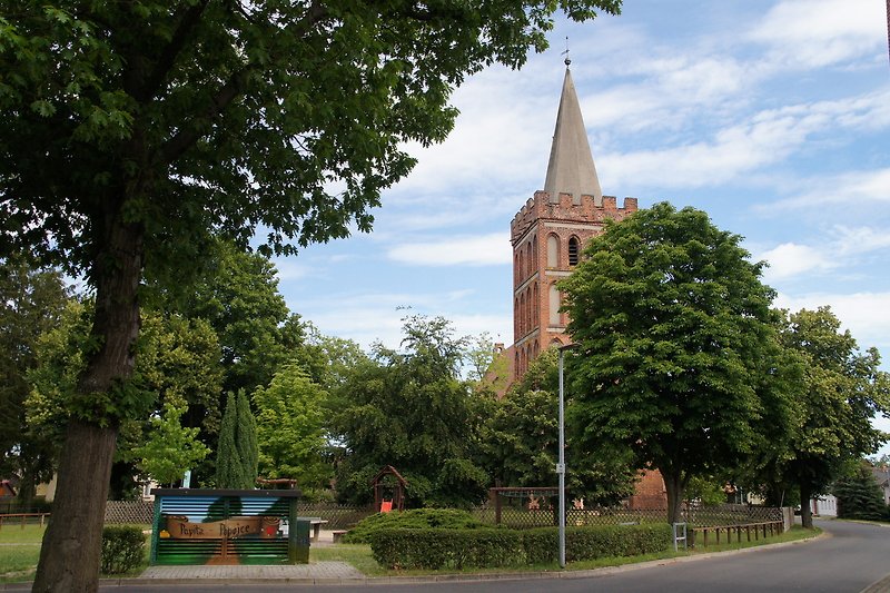 Dorfbild mit Kirche, Turm und Grünflächen