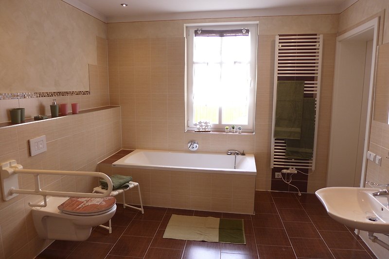Modernes Badezimmer mit Badewanne und Fenster.