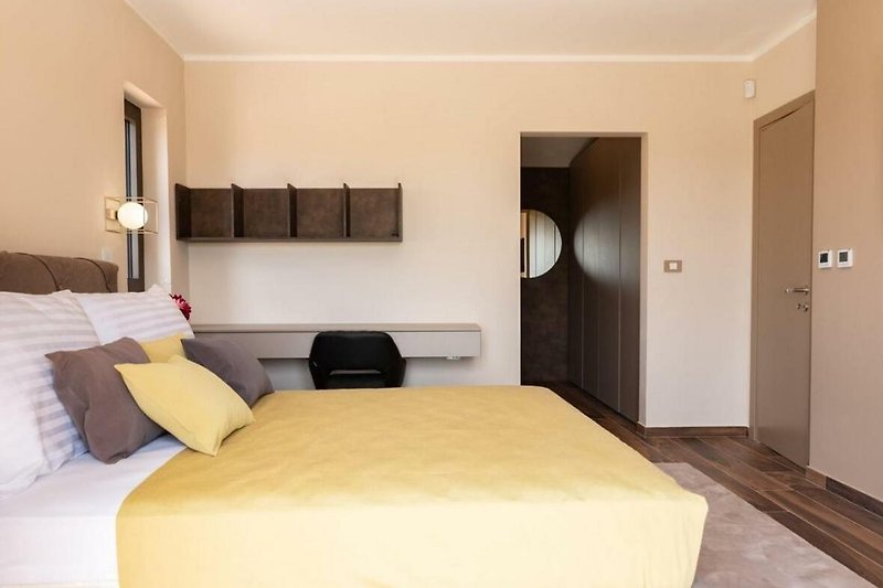 Elegantes Schlafzimmer mit Holzmöbeln und gemütlichem Bett.