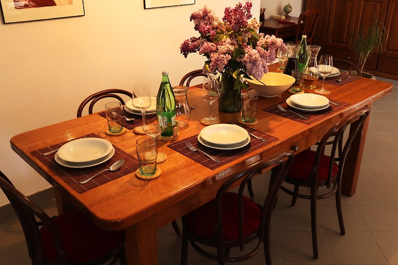Elegante Tischdekoration mit Porzellan, Blumen und Kerzen.