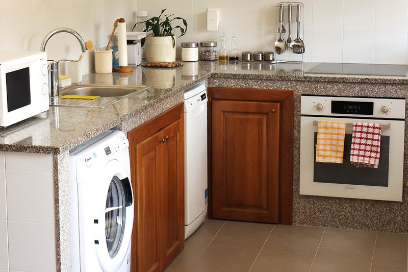 Moderne Küche mit braunen Schränken, Holzarbeitsplatte und Gasofen.
