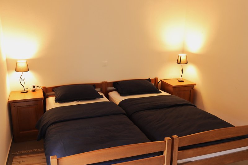 Schlafzimmer mit gemütlichem Bett, stilvoller Beleuchtung und Nachttisch.