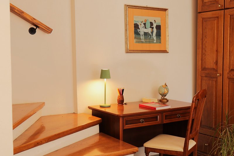 Wohnzimmer mit Holzmöbeln, Lampe, Sofa und Pflanze.