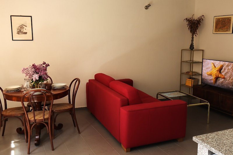 Stilvolles Wohnzimmer mit bequemer Couch, Tisch, Pflanze und Lampe.