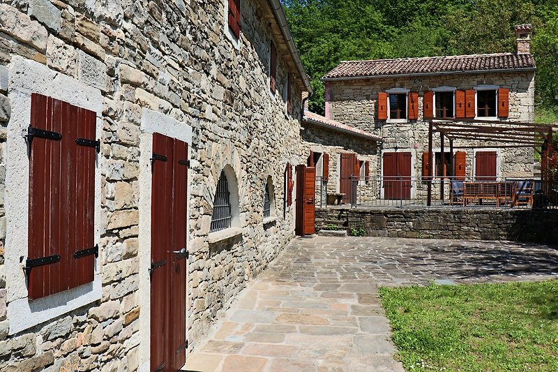 Historisches Dorfhaus mit Steinmauern und Fachwerk.