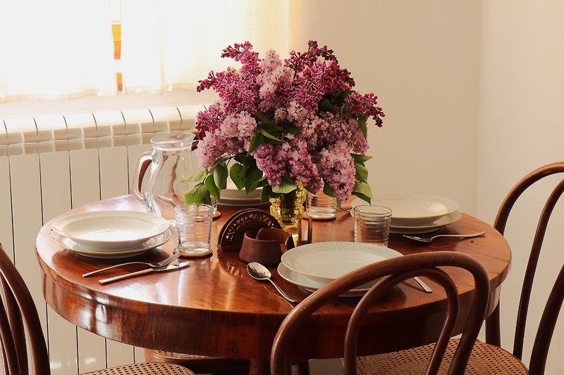Elegante Tischdekoration mit Blumen, Geschirr und Vasen.