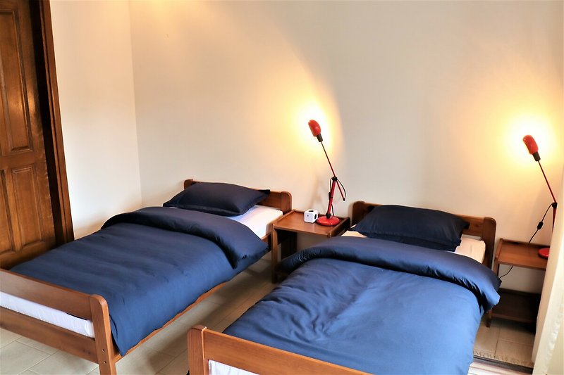 Modernes Schlafzimmer mit stilvoller Beleuchtung und gemütlichem Bett.