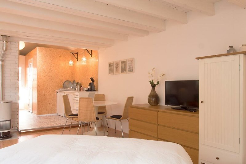 Elegantes Zimmer mit Holzmöbeln, Fernseher, bequemem Bett und stilvoller Einrichtung.