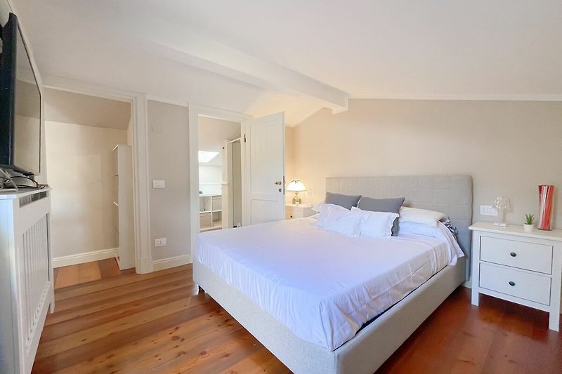 Schlafzimmer 1 mit 160cm breitem Bett Holzparkett und eigenem Duschbad