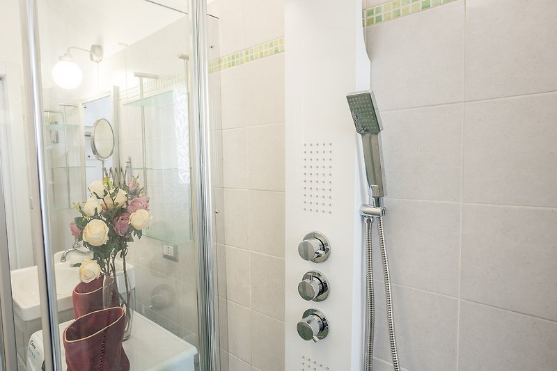 Modernes Badezimmer mit Glasdusche, Pflanze und stilvoller Einrichtung.