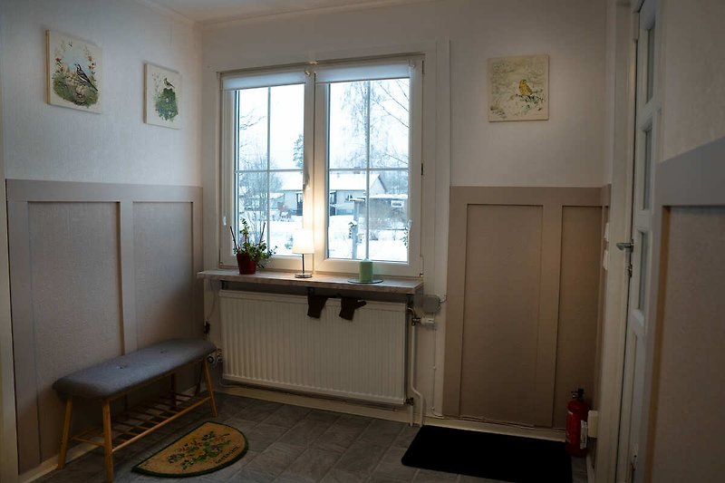 Raum mit Holzfenster, Tür, Decke und Pflanze.