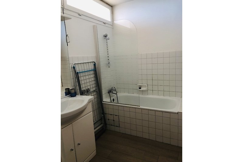 Badezimmer mit Spiegel, Badewanne und Waschbecken.