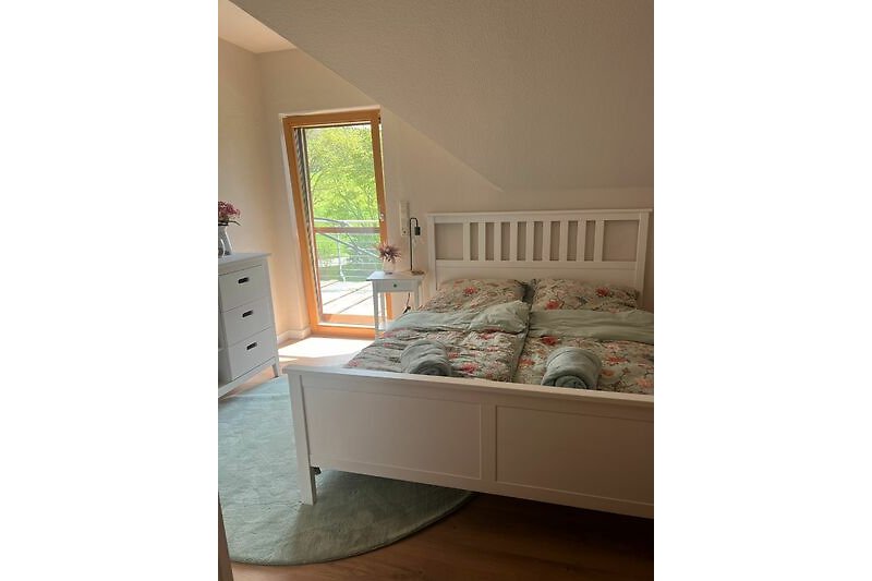 Ein Schlafzimmer mit elegantem Holzmöbel, bequemem Bett und stilvoller Einrichtung.