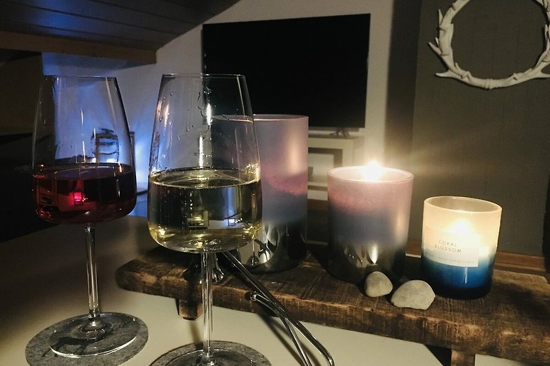 Elegante Tischdekoration mit Kerzen, Weingläsern und Wein. Stilvolles Ambiente.