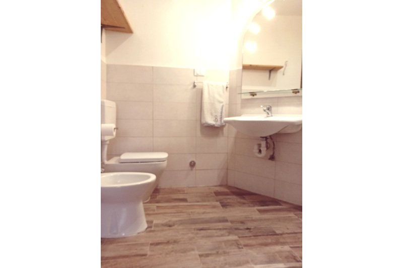 Badezimmer mit lila Vorhang, Keramikwaschbecken und Toilette.