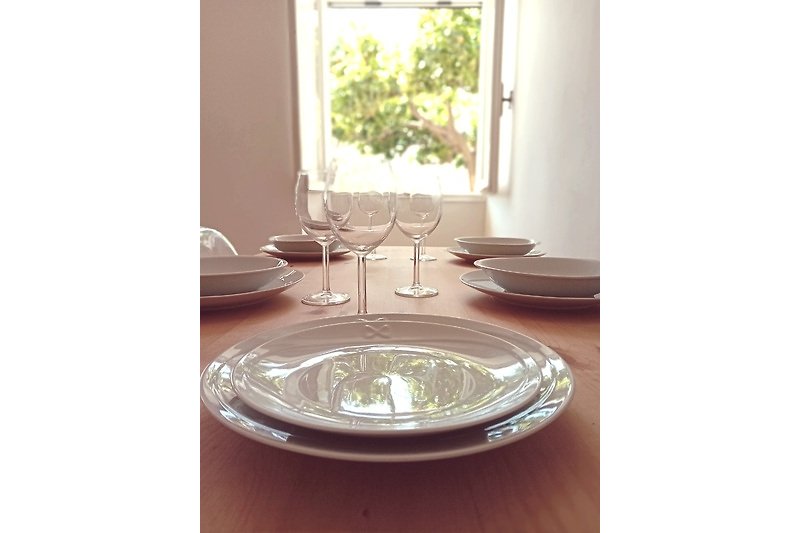 Elegante Tischdekoration mit Glas, Porzellan und Besteck.