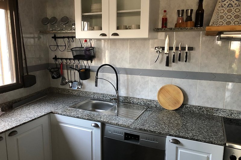 Moderne Küche mit Granit-Arbeitsplatte und Edelstahl-Spüle.
