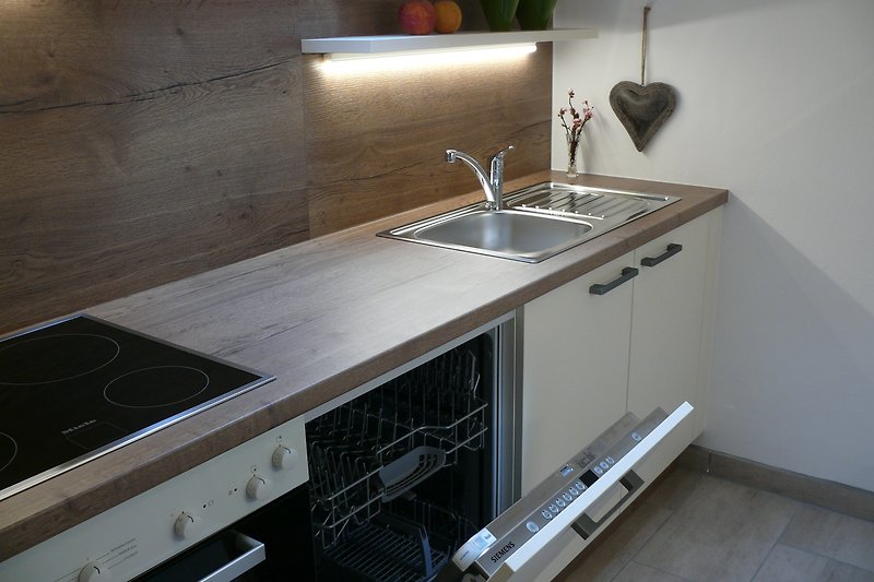 Moderne Küche mit Gasofen, Granit-Arbeitsplatte und Spülmaschine. Edle Ausstattung.