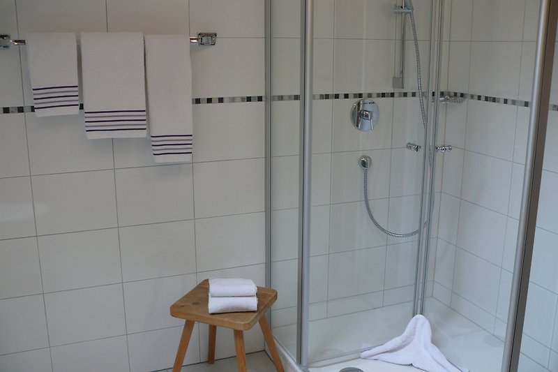 Modernes Badezimmer mit Glasdusche und Holzakzenten. Alles für Ihren Komfort.