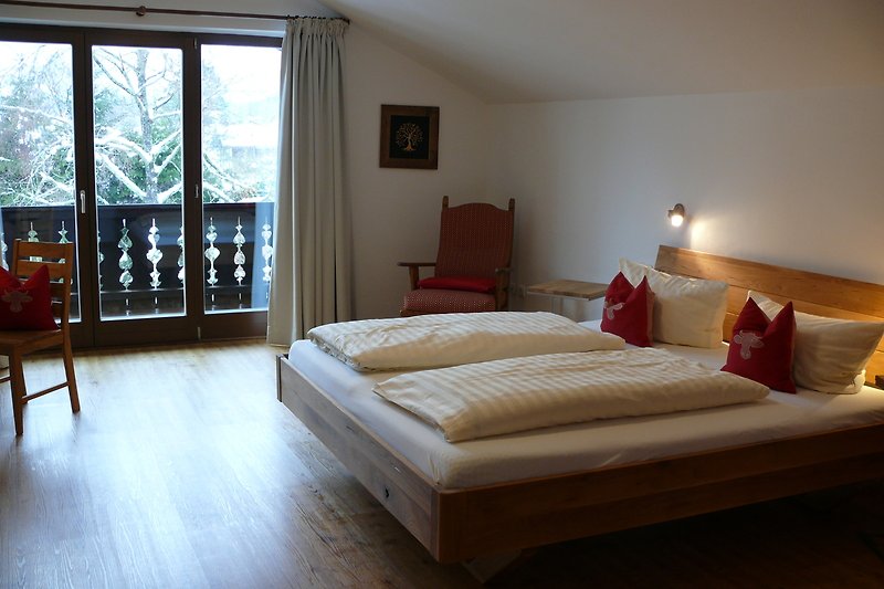 Schlafzimmer mit Holzmöbeln, Bett und Fenster. Gemütliche Inneneinrichtung.