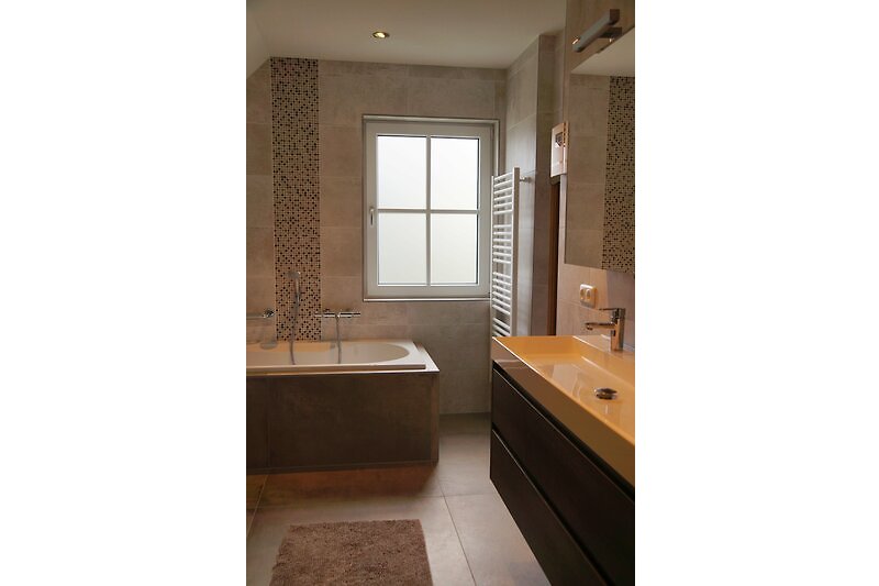 Badezimmer mit Fenster, Waschbecken und Holzschrank. Tageslicht.