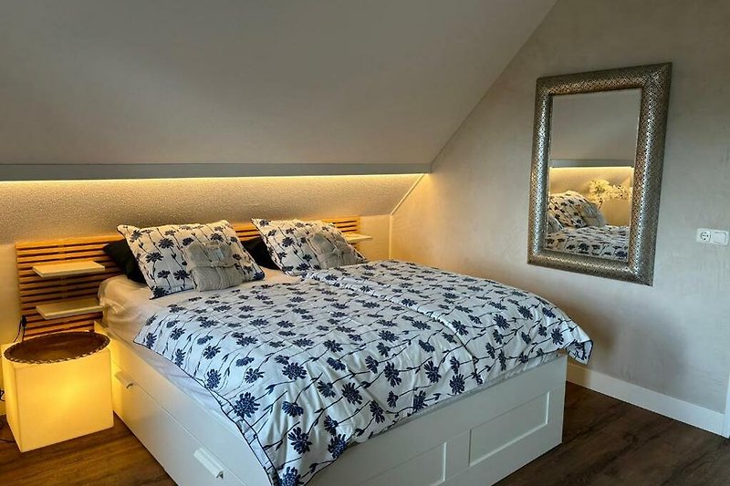 Holzbett, Kissen, Lampe - stilvolles Schlafzimmer.