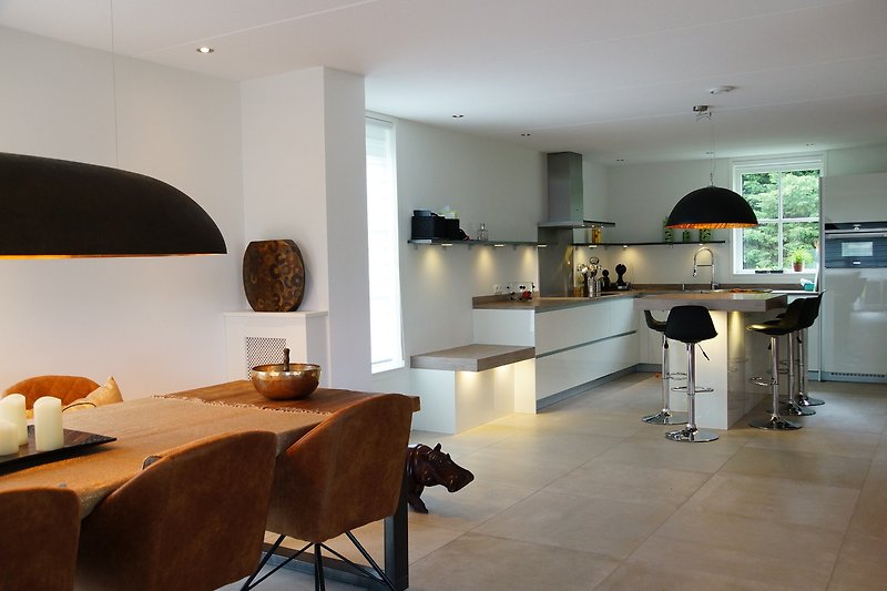 Moderne Küche mit Holzmöbeln, Lampen und Küchengeräten.
