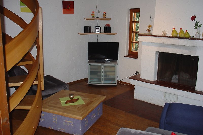 Wohnzimmer mit Kamin und Fernseher.