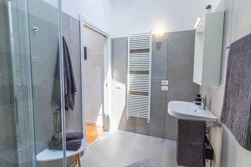 Modernes Badezimmer mit Spiegel, Waschbecken und Gasheizung.