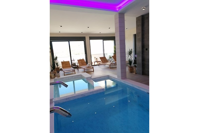 Luxuriöses Wohnzimmer mit Poolblick und moderner Einrichtung.