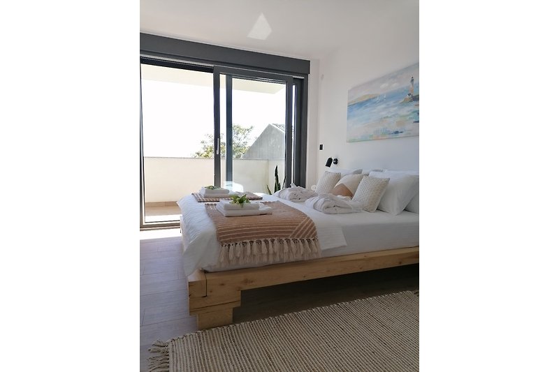 Modernes Schlafzimmer mit elegantem Holzbett und gemütlichen Kissen.