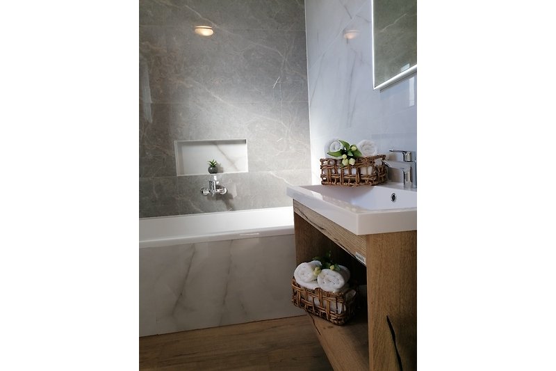 Modernes Badezimmer mit Waschbecken, Spiegel und Schrank.