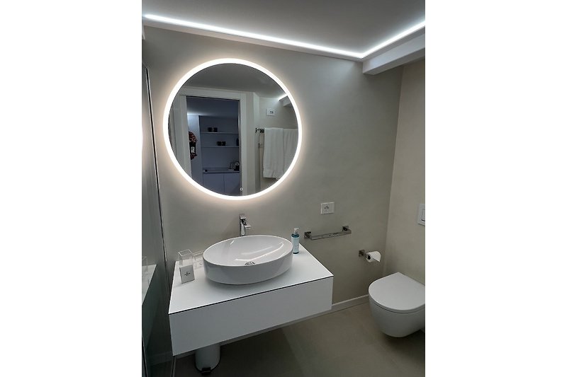 Modernes Badezimmer mit ovaler Badewanne und Spiegel.