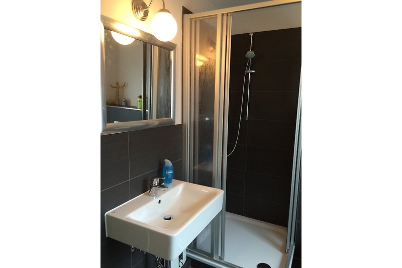 Modernes Badezimmer mit rechteckigem Waschbecken und Metallarmatur.