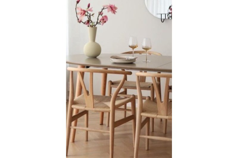 Moderne Küche mit Holztisch, Stühlen, Vase und Lampe.