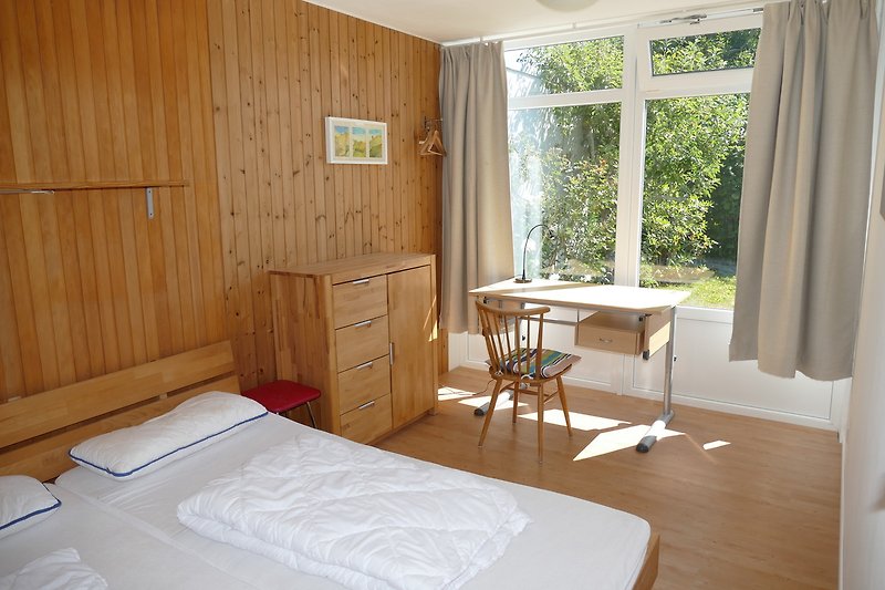 Großes Schlafzimmer mit bequemem Bett und Holzmöbeln.