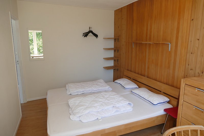 Großes Schlafzimmer mit bequemem Bett und Holzmöbeln.
