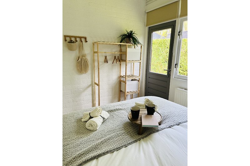 Schlafzimmer mit gemütlichem Bett, Kissen und Fenster.