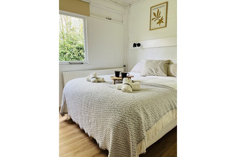 Elegantes Schlafzimmer mit Holzbett, Kissen und Dekoration.