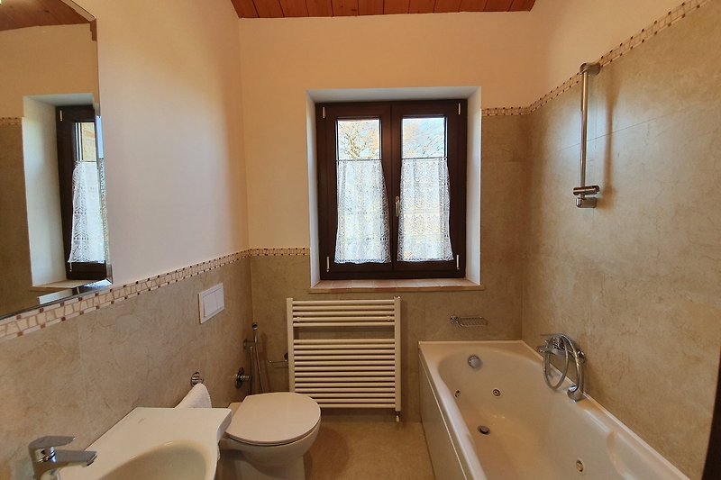 Modernes Badezimmer mit Badewanne, Spiegel und Fenster - stilvoll gestaltet!