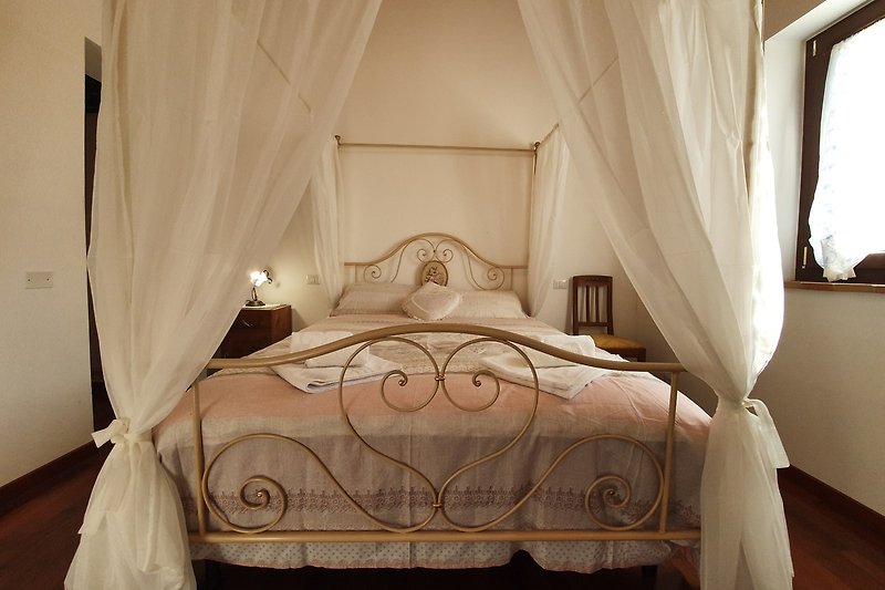 Stilvolles Schlafzimmer mit Holzbett, Vorhängen und Deckenlampe - elegant eingerichtet!