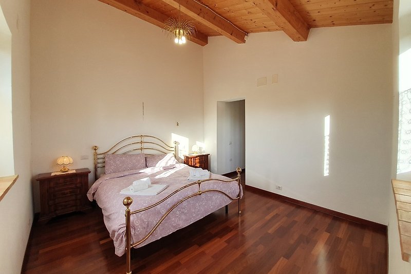 Stilvolles Schlafzimmer mit Holzbett und gemütlicher Bettwäsche - einladend!