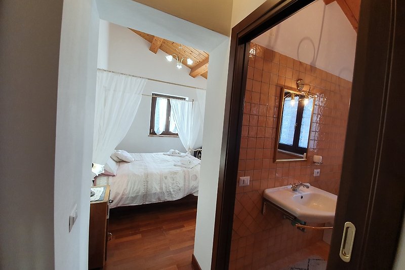 Schlafzimmer mit Holzbett, Spiegel und Nachttisch - stilvoll eingerichtet!