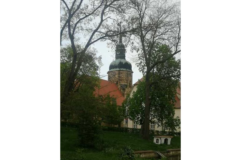 Historische Kirche mit Architektur und Grünflächen.
