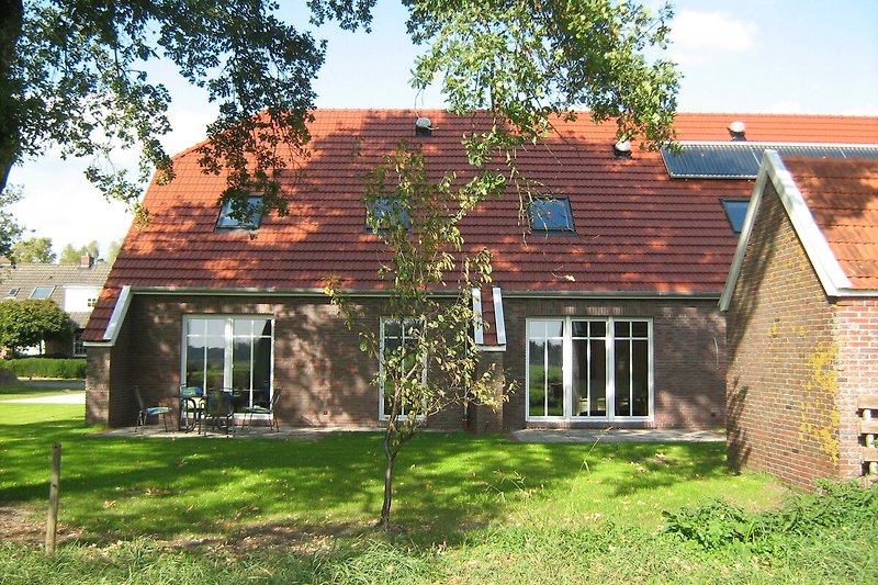 Historisches Haus mit Ziegelmauerwerk und gepflegtem Garten.