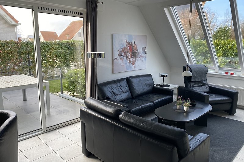 Modernes Wohnzimmer mit bequemer Couch, Pflanzen und Tisch.